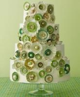 4- tier wedding cake with gold, green and white flowers.